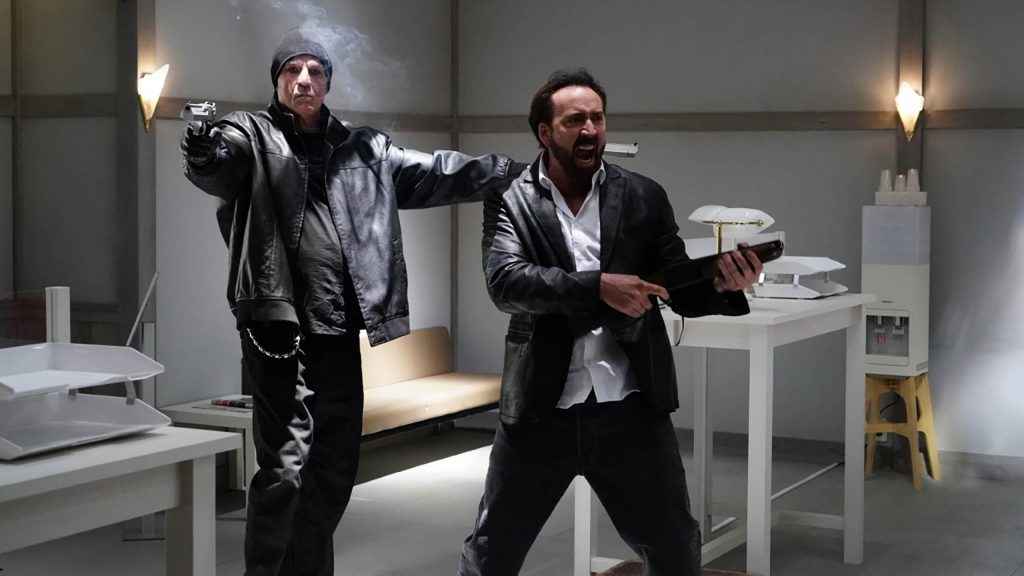 Nick Cassavetes and Nicolas Cage robbing a bank with force as seen in Prisoners of the Ghostland. 