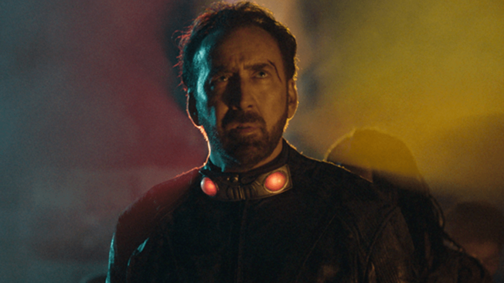 Nicolas Cage wearing a suit with bombs attached to his neck as seen in Prisoners of the Ghostland.