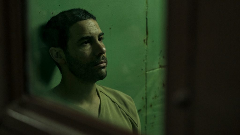 Tahar Rahim as Mohamedou Ould Slahi in a jail cell as seen in The Mauritanian.