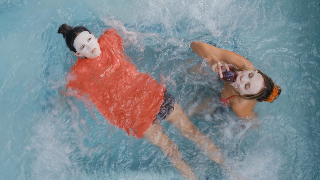 Jenny Ortega and Maddie Ziegler sunbathing in a pool as seen in the SXSW film The Fallout.