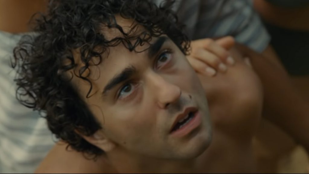 Alex Wolff looking to the sky with tears in his eyes as seen in the new M. Night Shyamalan Horror Thriller OLD.