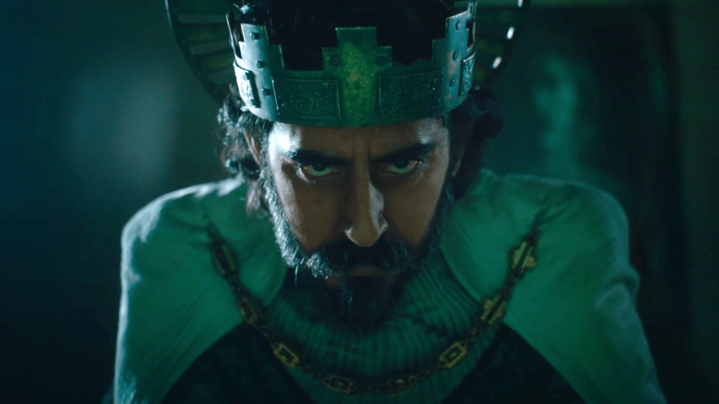 Dev Patel starring intimately at the camera while wearing