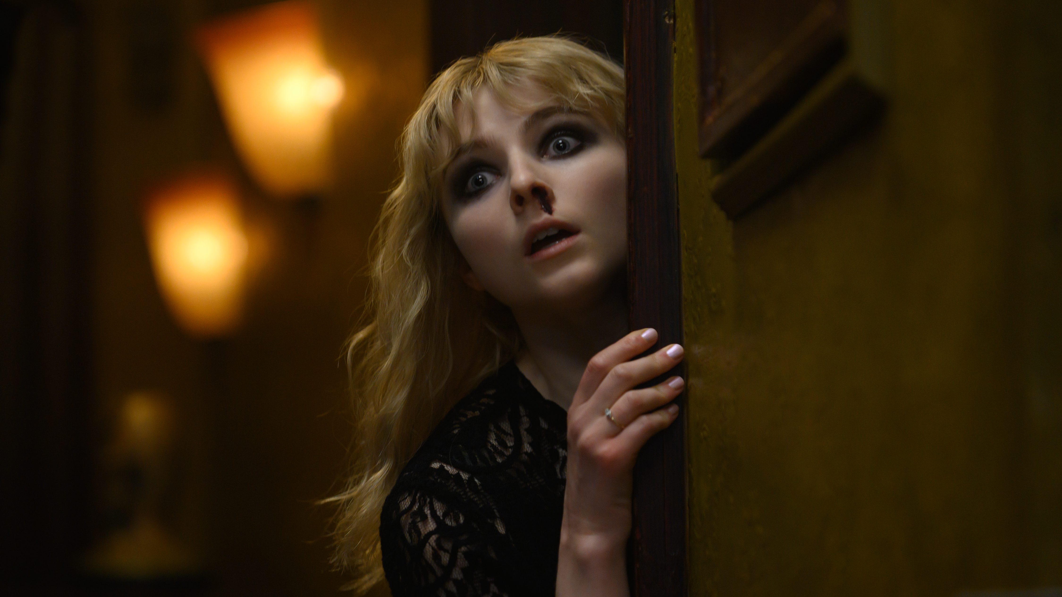 Thomasin McKenzie looking distraught in fear with deep black eye shadow and a bleeding nose as seen in LAST NIGHT IN SOHO directed by Edgar Wright.