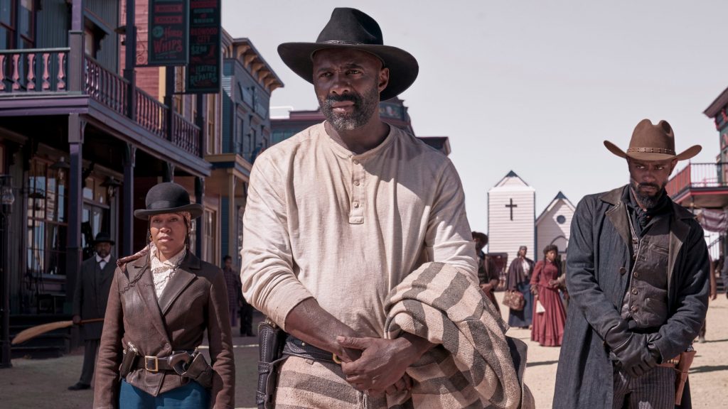 Regina King as Trudy Smith, Idris Elba as Rufus Buck, and LaKeith Stanfield as Cherokee Bill stand together in the middle of an old western town as seen in the new Netflix movie THE HARDER THEY FALL.