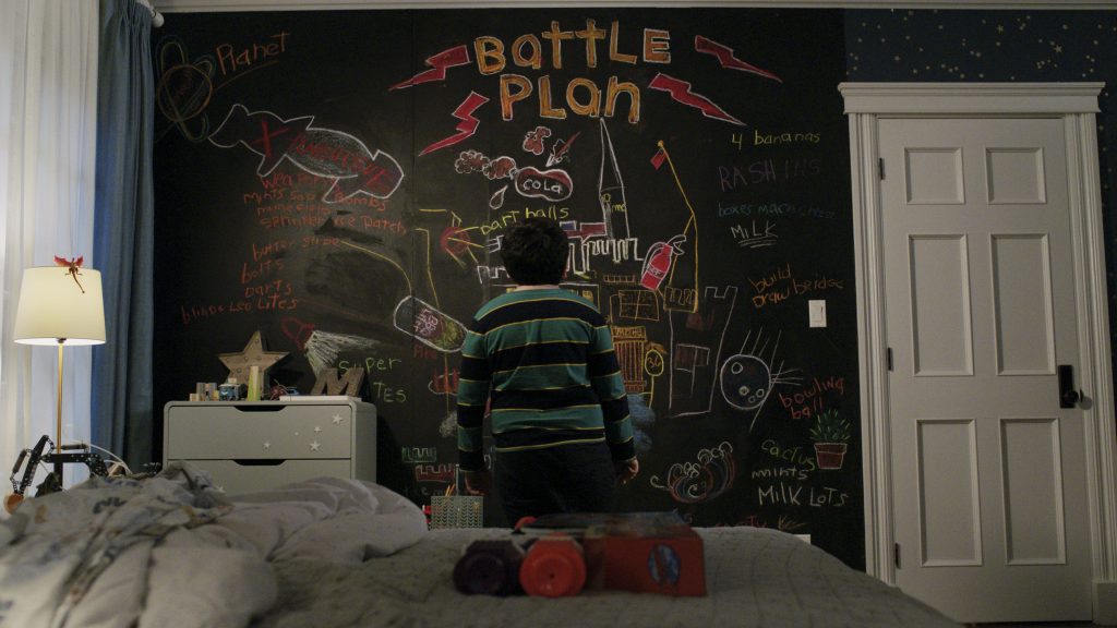 Archie Yates as young Max Mercer looking at his battle plan drawn all over his wall in colorful chalk with traps and weapons in the new Disney+ Home Alone sequel HOME SWEET HOME ALONE directed by Dan Mazer.