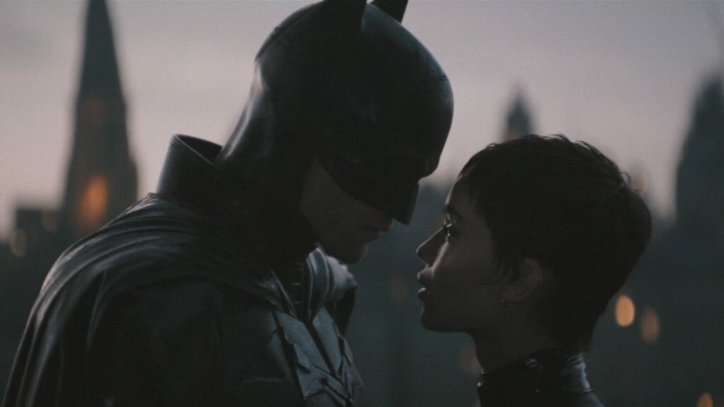 Robert Pattinson as Batman and Zoë Kravitz as Catwoman lock eyes in the 2022 film THE BATMAN.