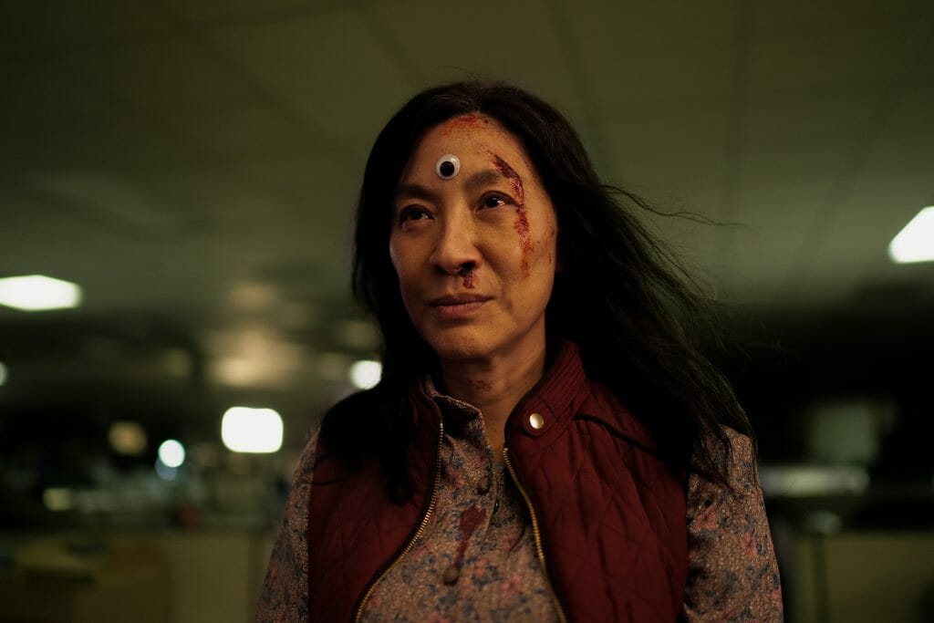 Michelle Yeah stands tall and strong covered with bruises and blood with exactly one googly-eye on her forehead in A24's multiverse action adventure EVERYTHING EVERYWHERE ALL AT ONCE.
