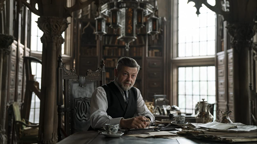 Andy Serkis as Alfred sitting at a grand table in the middle of a gothic looking chamber in Wayne Tower as seen in THE BATMAN produced by Dylan Clark and directed by Matt Reeves.