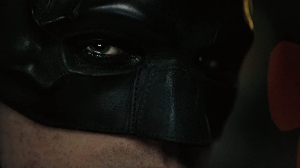 A dramatic close up of Robert Pattinson's Batman cowl and eye makeup as seen in THE BATMAN coming to HBO Max in April 2022.