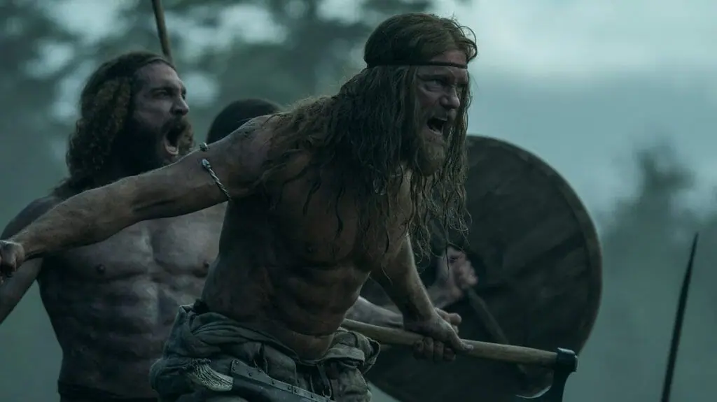 Alexander Skarsgård screams into battle with his fellow shirtless vikings like a pack of wild animals in THE NORTHAMAN directed by Robert Eggers.