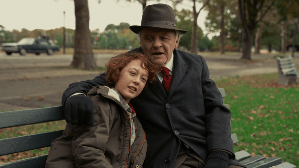 Anthony Hopkins hugs and shares words of wisdom to a young Banks Repeta on a New York park bench covered in autumn leaves in ARMAGEDDON TIME directed by James Gray.