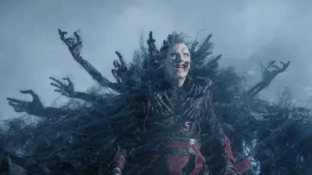 A zombie version of Doctor Strange prepares to take flight as dark black demon souls wrap their skeleton hands around him to form a ghostly cloak of levitation in DOCTOR STRANGE IN THE MULTIVERSE OF MADNESS directed by Sam Raimi and written by Michael Waldron.