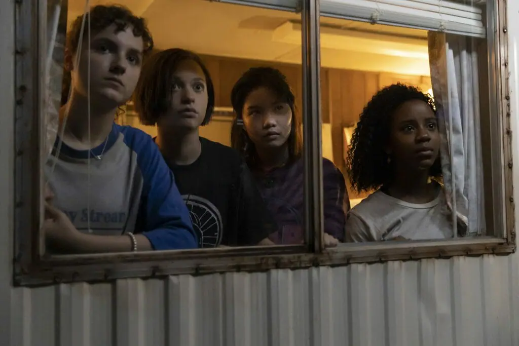 The Paper Girls gather together and stare out of a trailer in the new Amazon Prime Video comic series PAPER GIRLS.