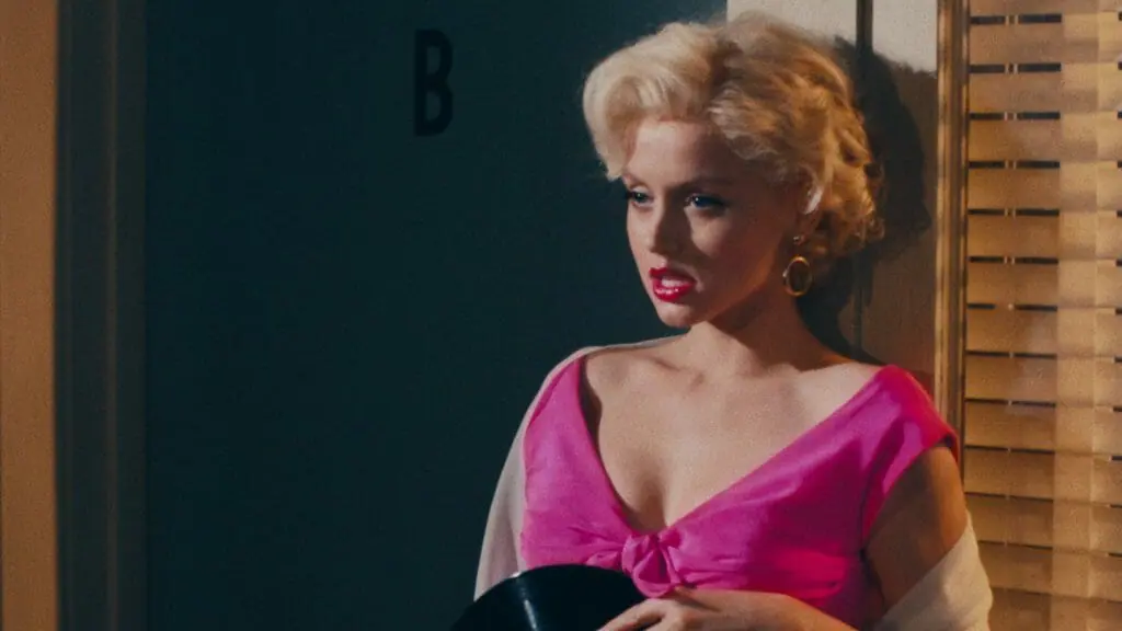 Ana de Armas poses as Marilyn Monroe wearing a bright pink dress in BLONDE coming to Netflix in September 2022.