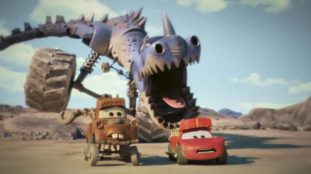 Lightning McQueen and Mater are chased by a large blue T Rex dinosaur car hybrid in the desert from the Disney+ original series CARS ON THE ROAD.