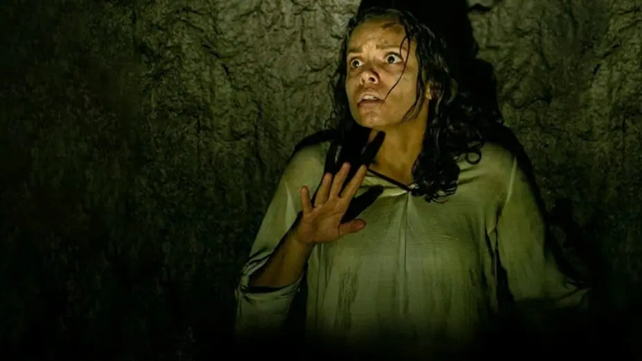 Georgina Campbell freezes in total fear as she crawls to the opposite side of an underground pit in BARBARIAN directed by Zach Cregger.