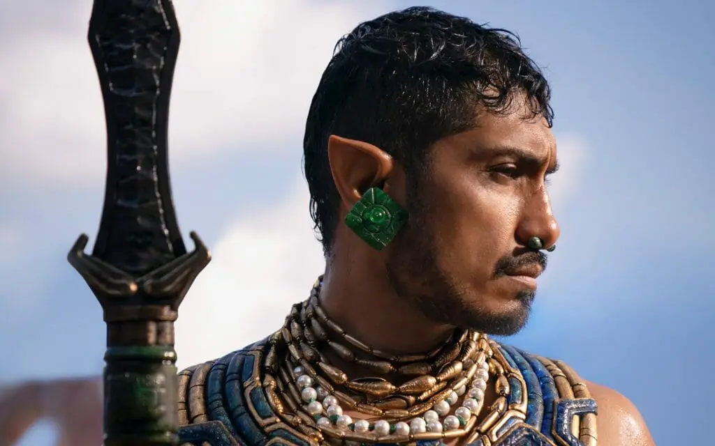 Tenoch Huerta strikes a majestic pose as Namor the ruler of Talocan holding his Mayan battle spear in BLACK PANTHER: WAKANDA FOREVER.