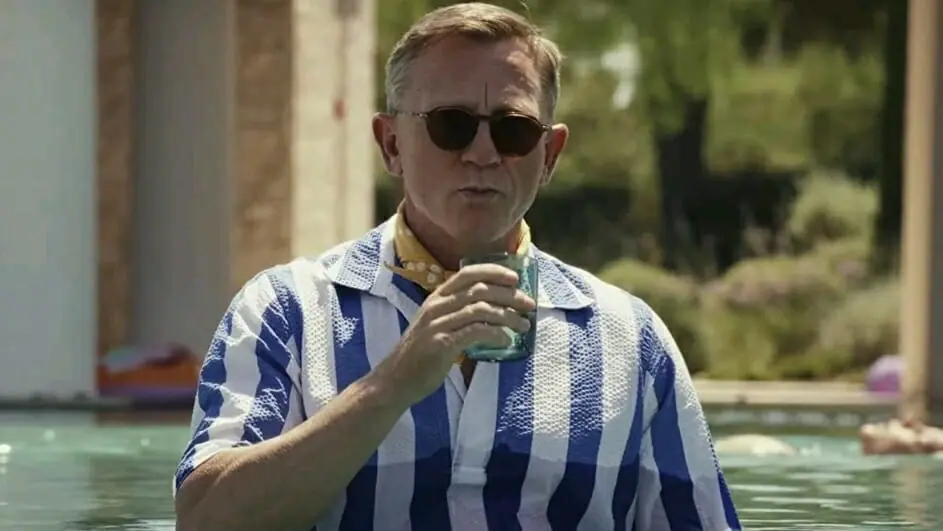 Daniel Craig stars as Benoit Blanc sipping a drink in the middle of a pool on a private Greek island in Glass Onion: A Knives Out Mystery, coming to Netflix in December 2022.