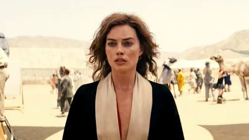 Margot Robbie as the rising Hollywood starlet Nellie LaRoy stands in the middle of a 1920s Los Angeles desert movie set in the historical film BABYLON.