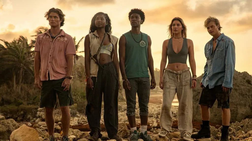 Chase Stokes, Carlacia Grant, Jonathan Daviss, Madelyn Cline, and Rudy Pankow star as the main group of teen Pogues stuck on their deserted island of Poguelandia in OUTER BANKS Season 3 on Netflix.