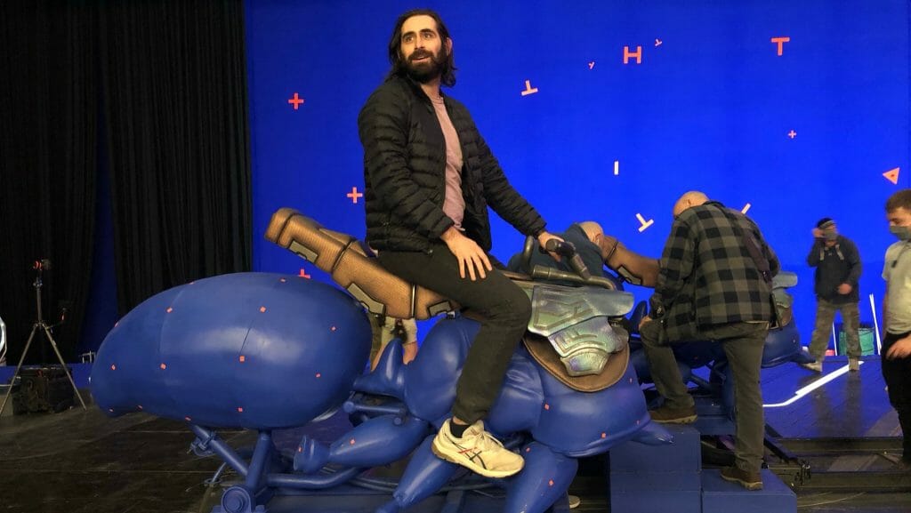 Writer Jeff Loveness rides a giant blue flying ant stand-in from the behind the scenes of ANT-MAN AND THE WASP: QUANTUMANIA. 