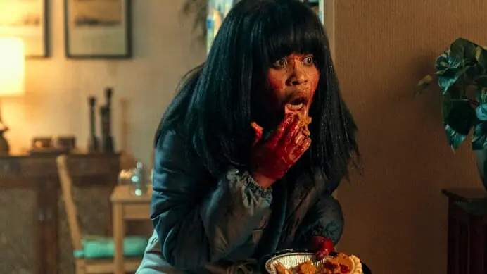 Dominique FIshback stars as Dre the killer stan with her hands covered in blood while holding a piece of pie in shock in the Amazon Prime Video original series SWARM.