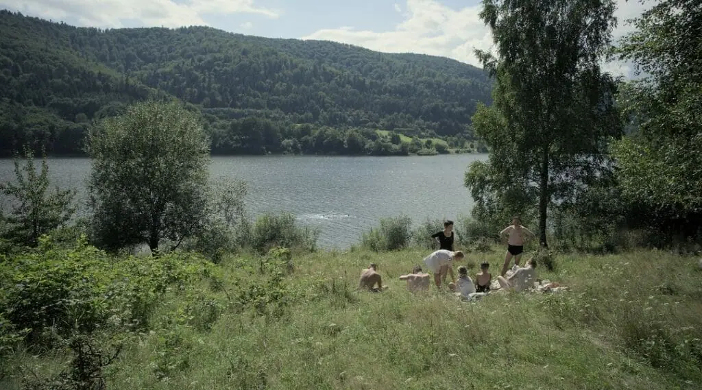 Auschwitz commandant Rudolf Höss and his wife Hedwig have a quiet picnic in the grass by a large beautiful lake with their five children in the Holocaust period drama film THE ZONE OF INTEREST.