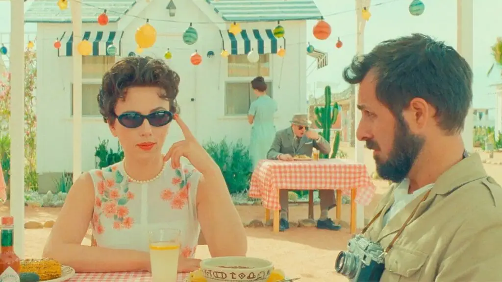 Scarlett Johansson and Jason Schwartzman sit and have lunch together outside during a bright sunny day in the small southwestern desert town of ASTEROID CITY.