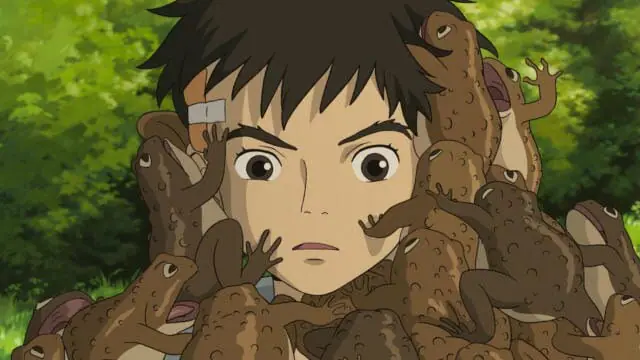 The young boy Mahito looks shocked as he's covered in toads and frogs in the animated film THE BOY AND THE HERON written and directed by Hayao Miyazaki
