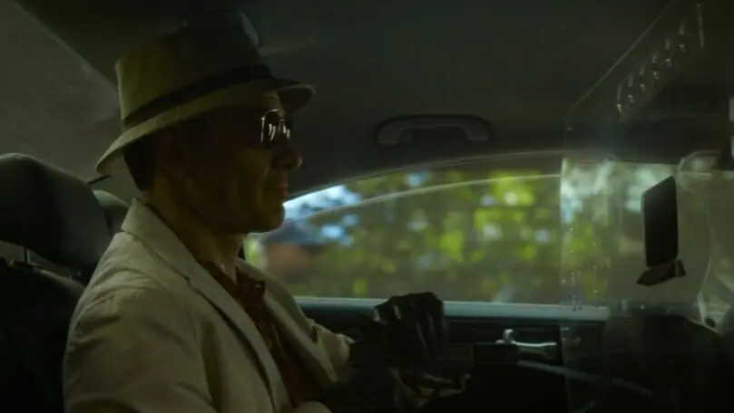 Michael Fassbender as the main nameless assassin loads a gun in the back of a taxi in the Netflix movie THE KILLER.