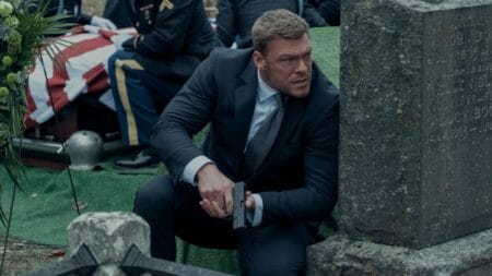 New Arrivals for Prime Video & Freevee 2023 Alan Ritchson stars as Jack Reacher taking cover from enemy fire behind a gravestone in an intense action sequence from REACHER Season 2 coming to Amazon Prime Video in December 2023.