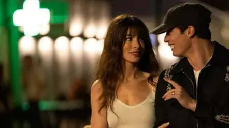 Anne Hathaway and Nicholas Galitzine walk together with locked arms in the com-com THE IDEA OF YOU which is new on Amazon Prime Video in May 2024.