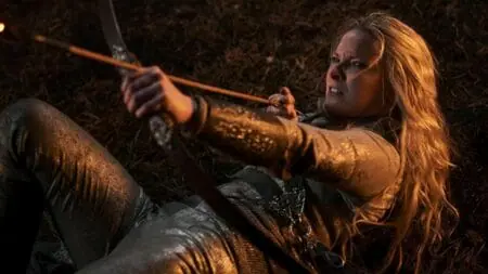 Morfydd Clark stars as the elf Galadriel firing her bow and arrow in an epic battle pose during a battle scene from THE LORD OF THE RINGS: THE RINGS OF POWER Season 2 on Amazon Prime Video.