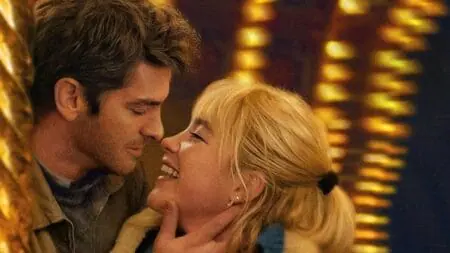 Andrew Garfield brings in Florence Pugh for a kiss while she gives a huge bright smile on the poster for the romantic drama film WE LIVE IN TIME.