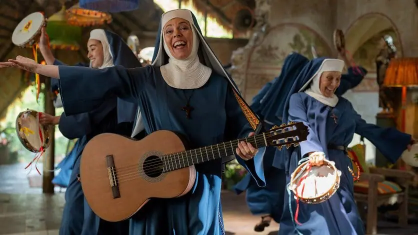 Olivia Colman performs a musical number with an acoustic guitar as the Reverend Mother of the home for retired bears in the film sequel PADDINGTON IN PERU. 