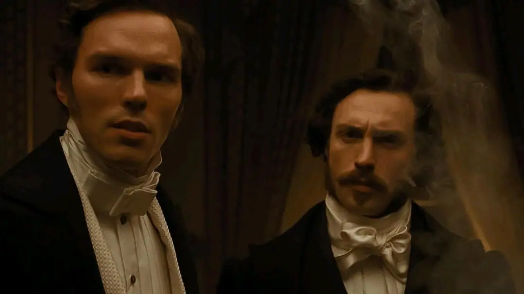 Nicholas Hoult as Thomas Hutter and Aaron Taylor-Johnson as Friedrich Harding pose together in their 1800s period accurate gentlemen costumes in Robert Eggers' NOSFERATU. 