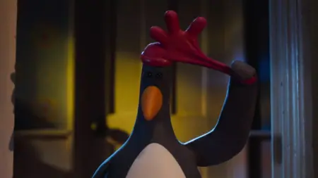 The villainous penguin Feathers McGraw puts on his iconic red rubber glove hat in the claymation film WALLACE & GROMIT: VENGEANCE MOST FOWL, coming to the Netflix streaming service in January 2025.