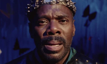 A close-up shot of actor Colman Domingo starring directly into the camera with powerful emotion while wearing a crown and dressed up as Hamlet in the critically acclaimed A24 prison drama SING SING, which is featured in the Max March 2025 list of new arrivals.