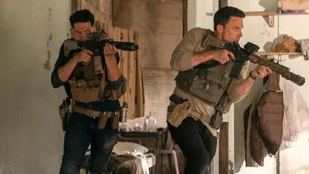 Ben Affleck and Jon Bernthal burst into action side by side wearing tactical gear and aiming assault rifles in the action thriller sequel THE ACCOUNTANT 2.