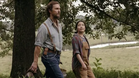 Matthew McConaughey and Angelina LookingGlass walk together across a vast beautiful Oklahoma field as rural beekeepers in the new crime thriller THE RIVALS OF AMZIAH KING.