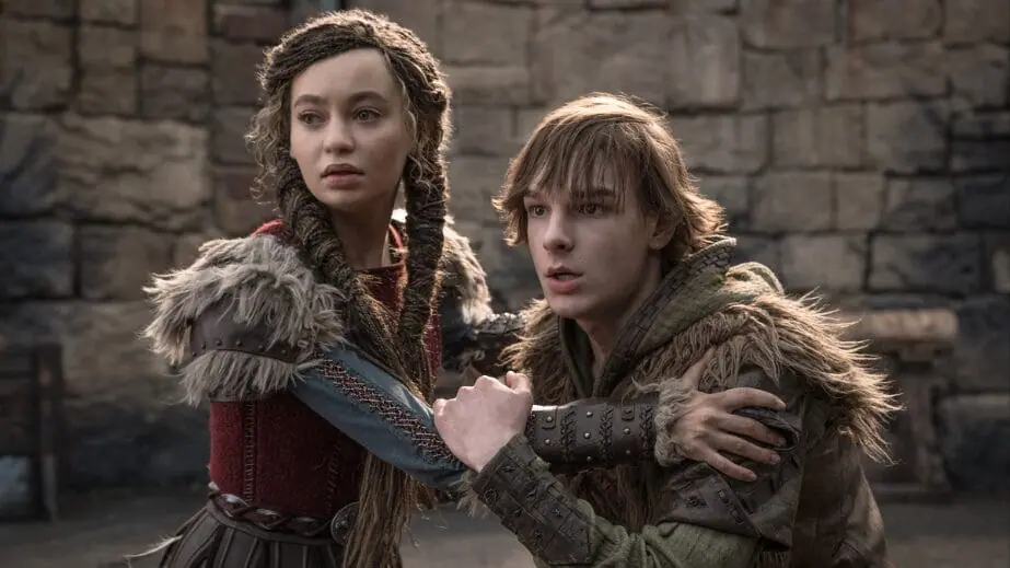Nico Parker and Mason Thames star as Astrid Hofferson and Hiccup hanging on to each other for dear life in the dragon-fighting training arena in the live-action HOW TO TRAIN YOUR DRAGON remake.  
