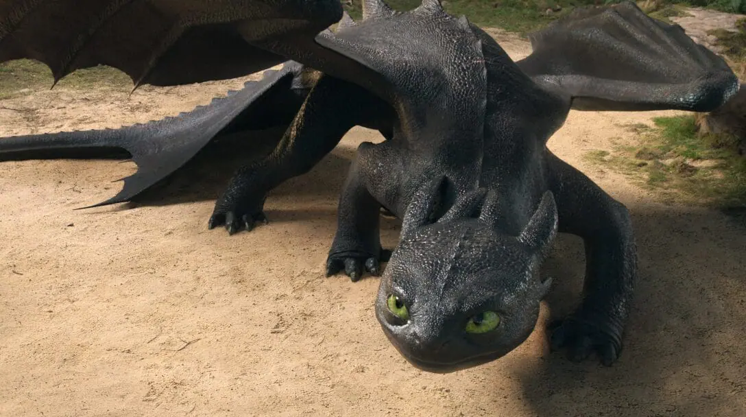 A wide shot of Toothless the large cute and black Night Fury dragon standing off in a defense position in the live-action HOW TO TRAIN YOUR DRAGON remake. 