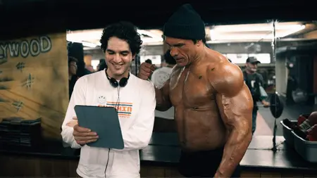 Benny Safdie Explains the Importance of Casting Real MMA Fighters in ‘The Smashing Machine’ Director Benny Safdie and actor Dwayne Johnson in character as iconic MMA fighter Mark Kerr look at a script together on the training gym set of their sports biopic THE SMASHING MACHINE.