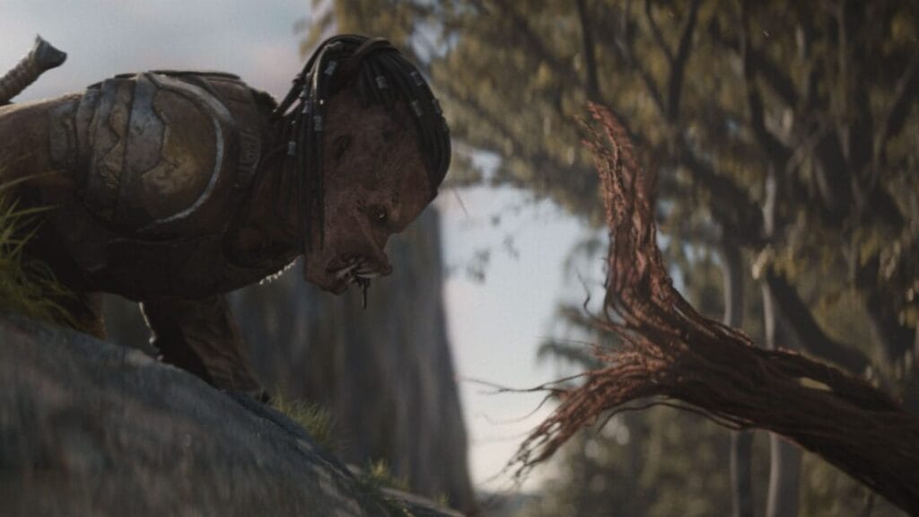 The runt Yautja warrior Dek comes face to face with a flesh-eating tree vine as it rushes towards him for an attack on the alien planet Genna in the movie PREDATOR: BADLANDS. 