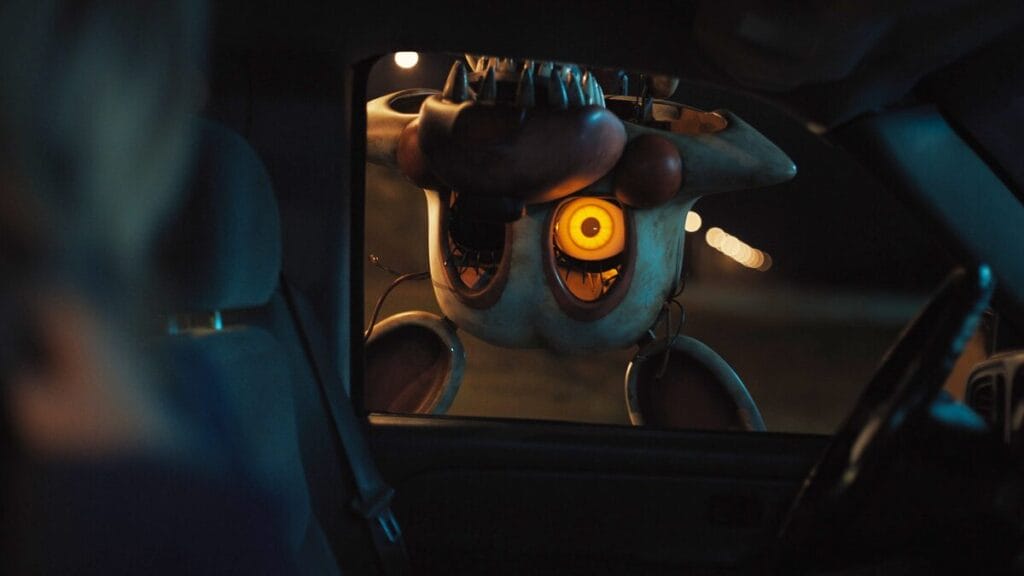 The monstrous life-sized animatronic Toy Foxy head of the Mangle monster shows itself as it hangs upside down from the roof of a car looking inside in the Blumhouse sequel FIVE NIGHTS AT FREDDY'S 2.