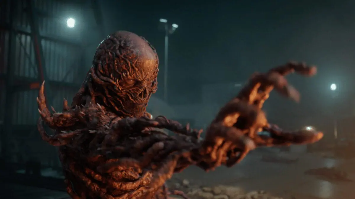 Vecna, the evil and disfigured monster who rules over the Upside Down, raises his hand to the camera as he uses his powerful telekinesis in Stranger Things Season 5. 