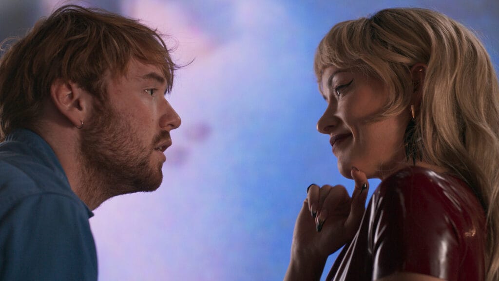 Cooper Hoffman and Olivia Wilde stare passionately into each other at a colorful art gallery in Gregg Araki's comeback film I WANT YOUR SEX.
