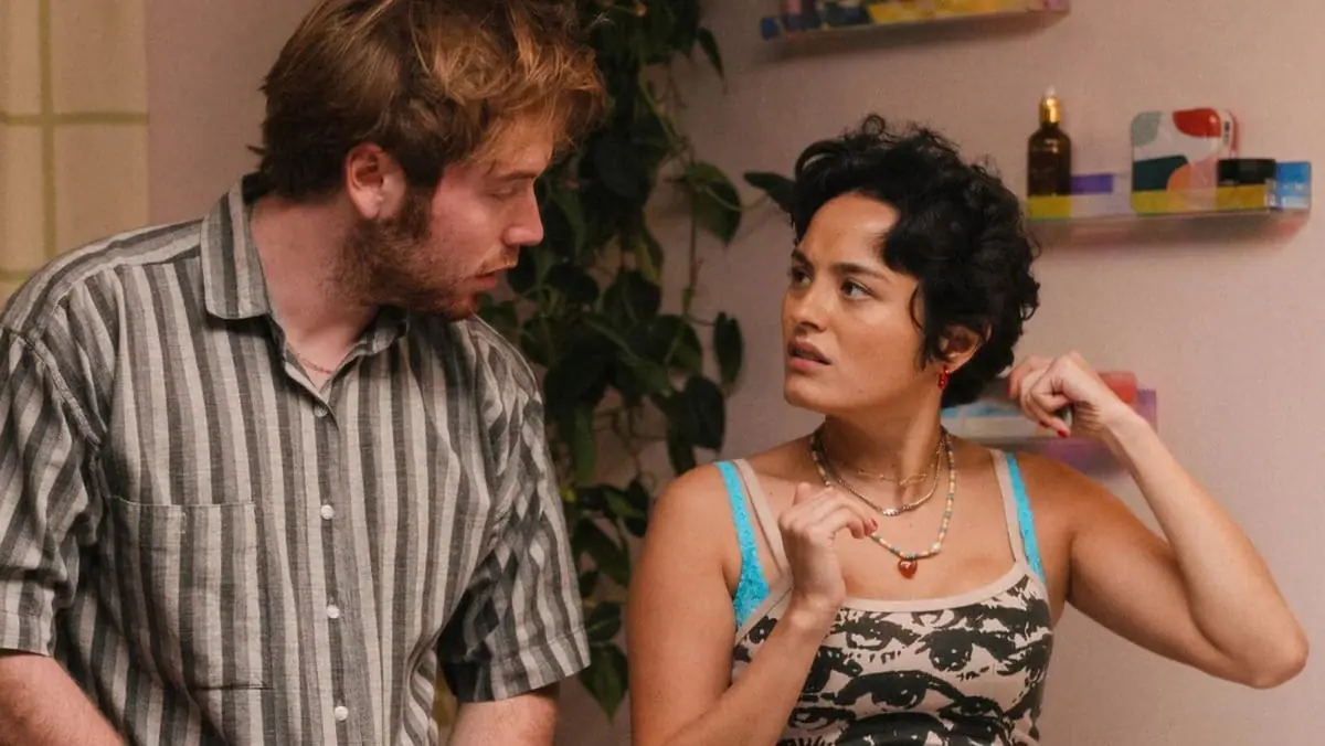 Cooper Hoffman and Chase Sui Wonders make awkward faces in their small apartment restroom as they get ready to go out in the comedy I WANT YOUR SEX.