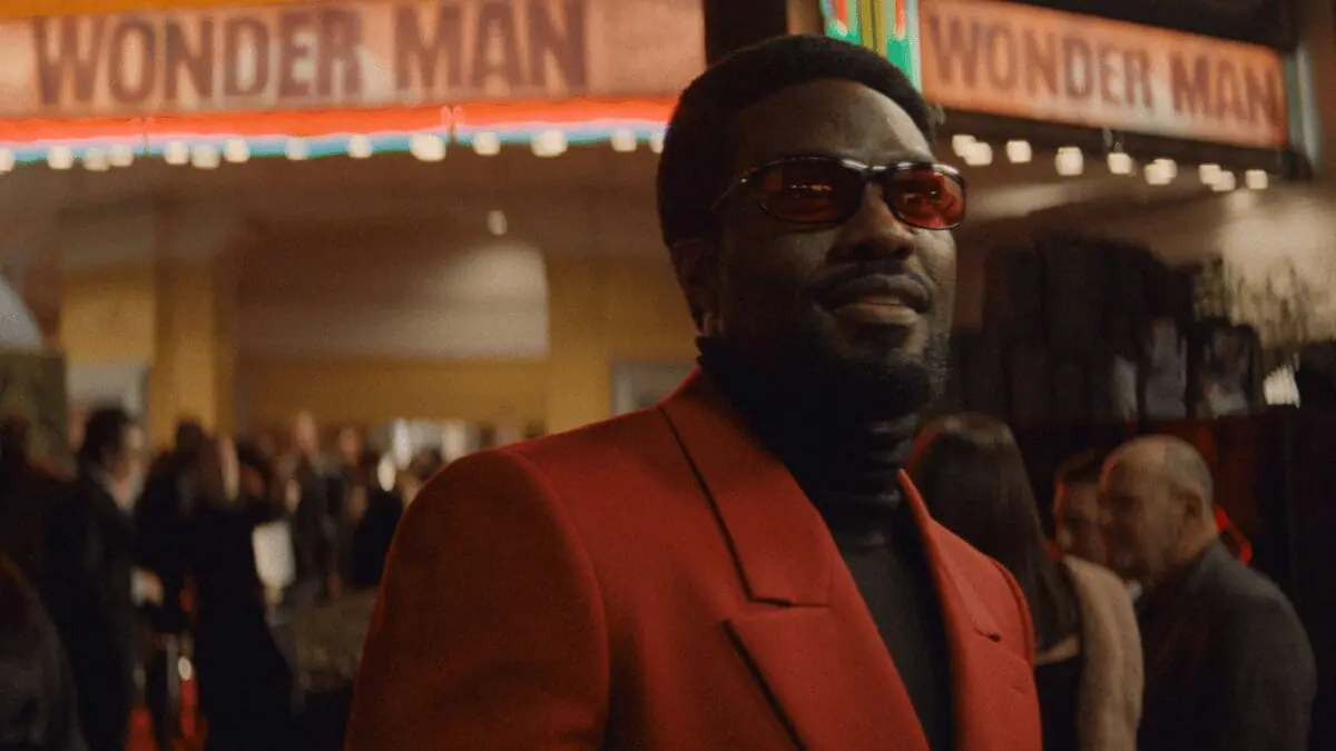 Yahya Abdul-Mateen II walks on a Hollywood red carpet as movie star Simon Williams with cameras flashing in his face in Marvel's WONDER MAN streaming only on Disney+.