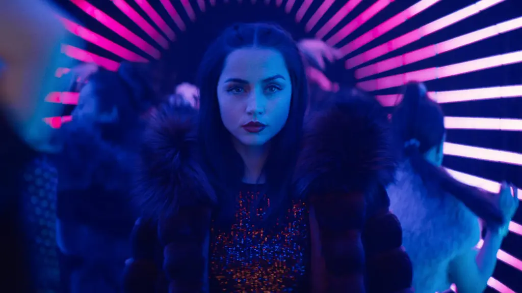 Ana de Armas stars as the assassin Eve Macarro looking cool as she walks through a tunnel with people dancing all around her in a club filled with neon purple lights in the John Wick spin-off film BALLERINA, which is included in the HBO Max March 2026 list of new movies and TV shows.